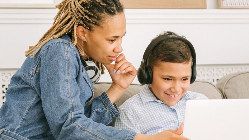 Mãe e filho estudando juntos no notebook (foto ilustrativa)